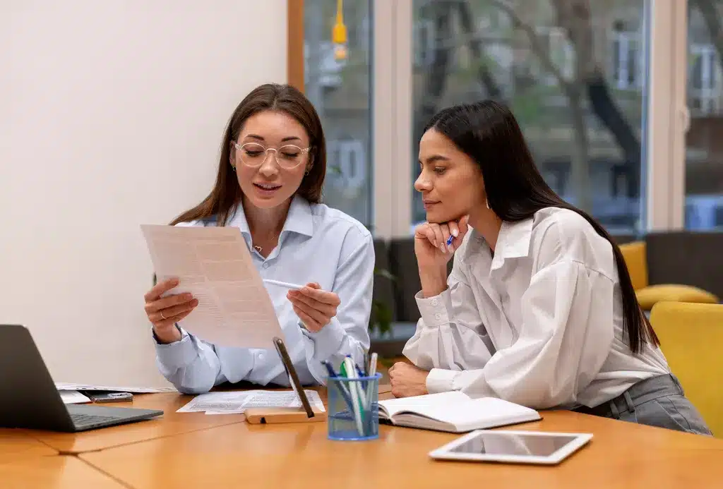 Two BizBud CPAs reviewing international tax documents at a desk