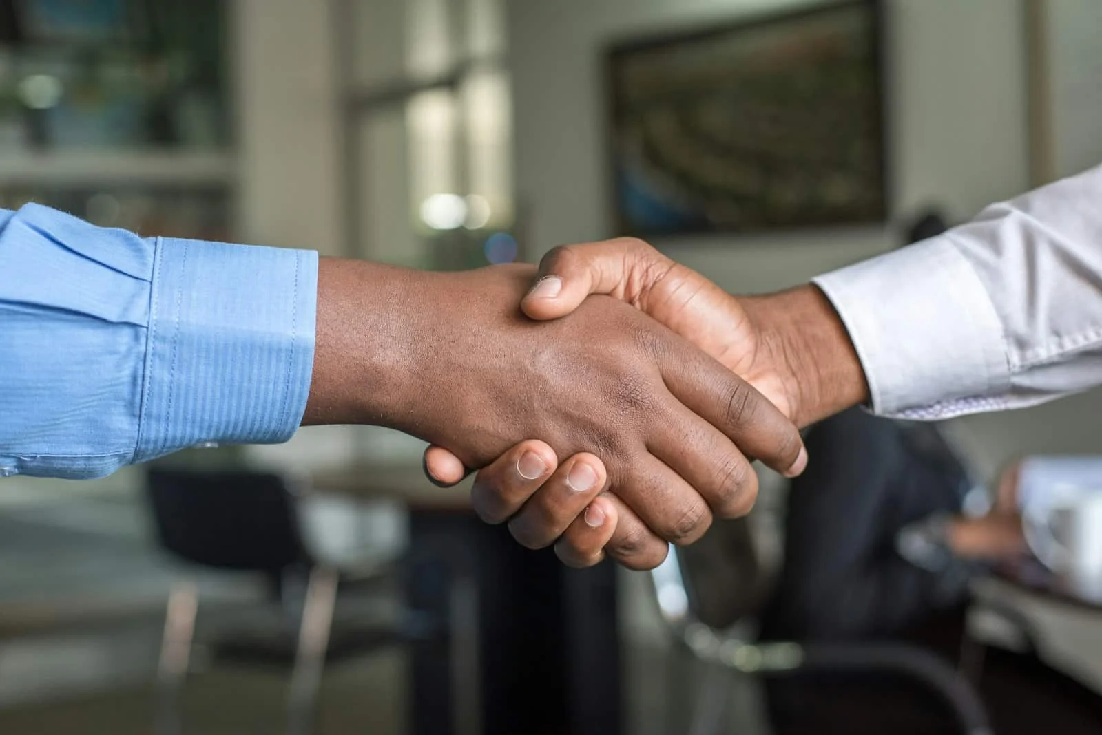 Two business professionals shaking hands over a partnership agreement